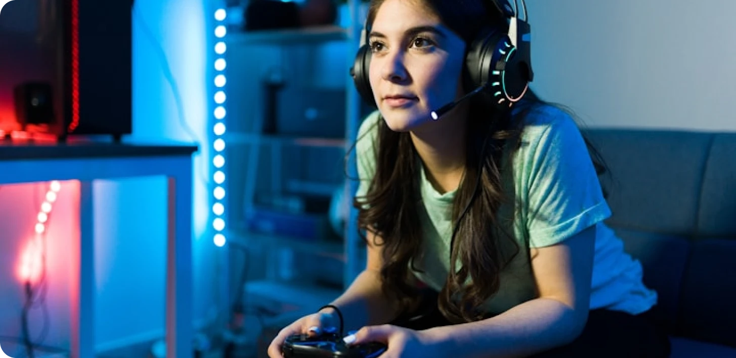 Jogadora usando headset e controle com iluminação em tons de azul e vermelho